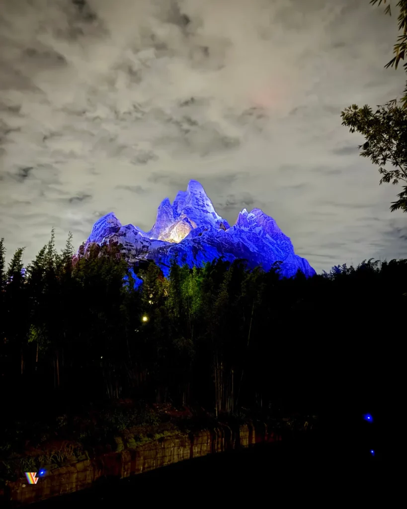 The mountain of Expedition Everest illuminated in blue colors at night.