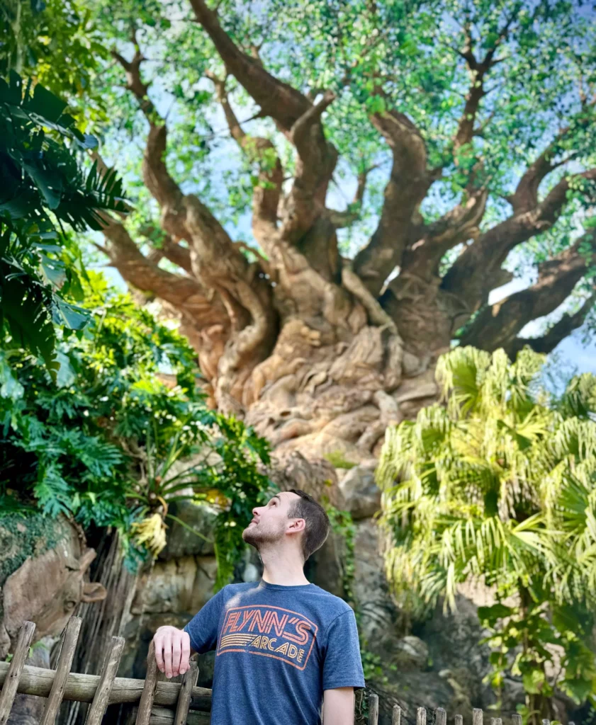 Christian McIlwain of Vertigo Views, a light skinned man looking up at the Tree of Life at Disney's Animal Kingdom