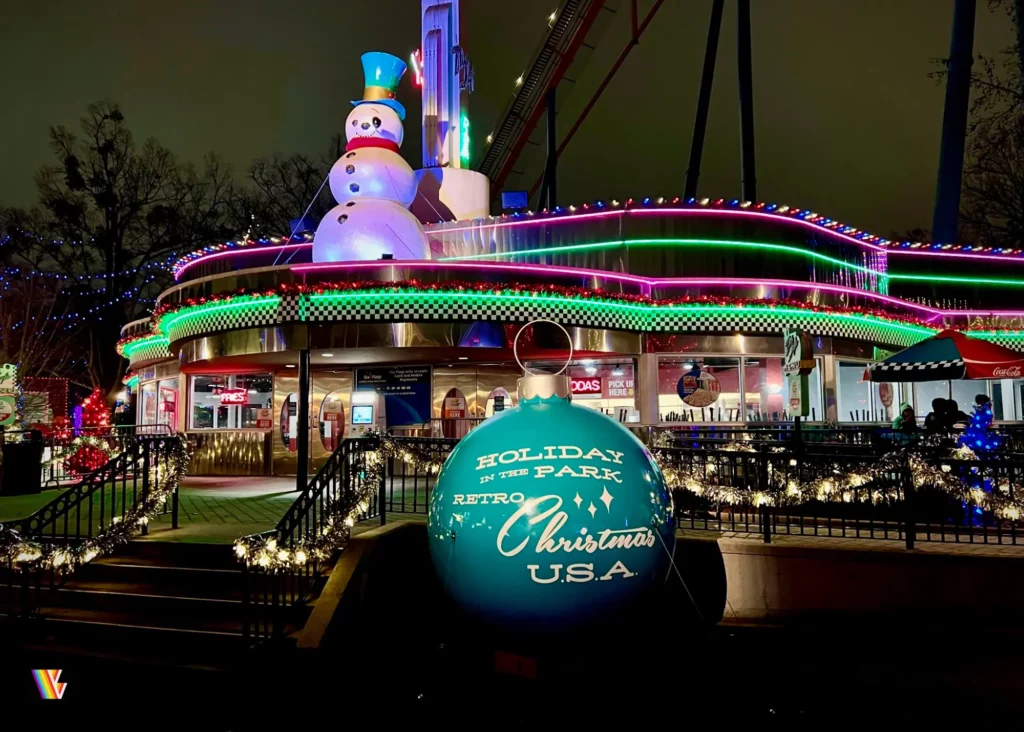 Dee Jay's Diner decorated in retro Christmas decorations for Holiday In The Park at Six Flags Over Georgia, including lights, a giant snowman, and a giant tree ornament