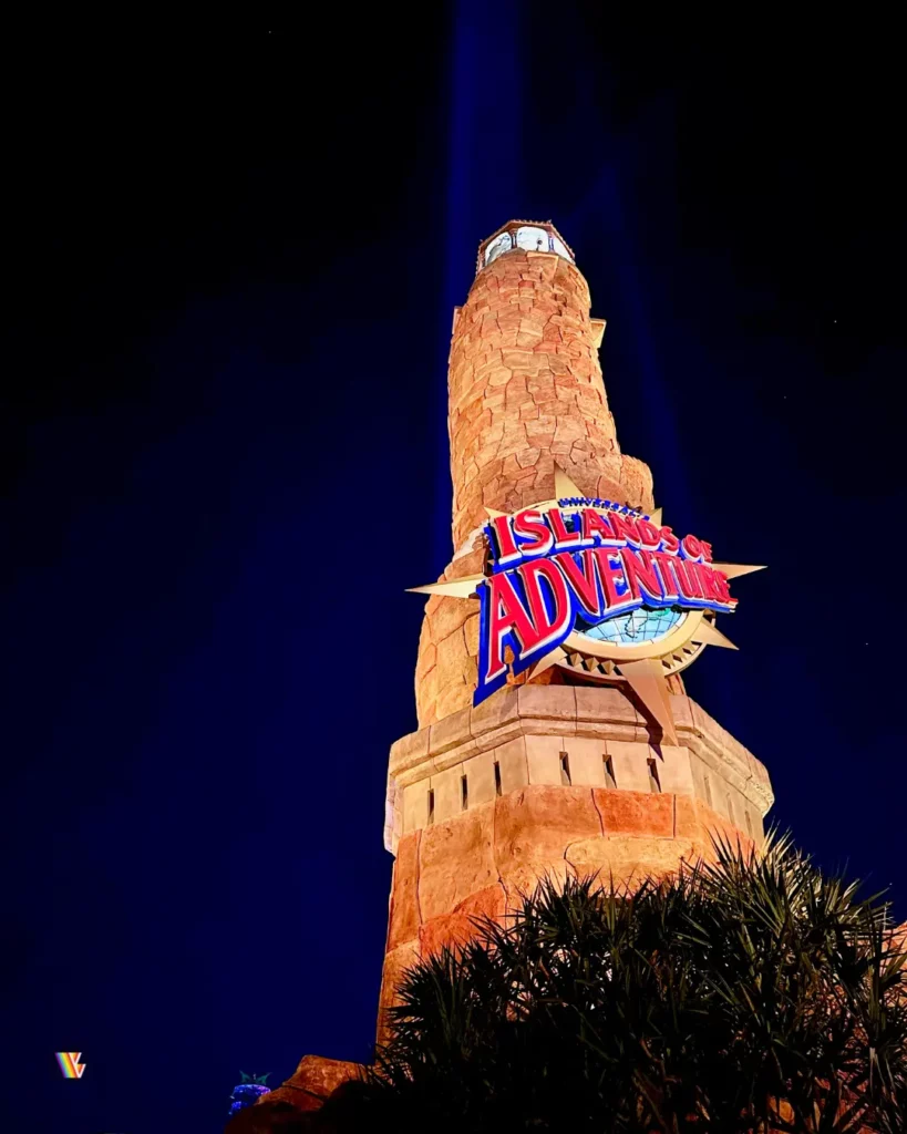 Looking up at lighthouse with Islands of Adventure logo at night