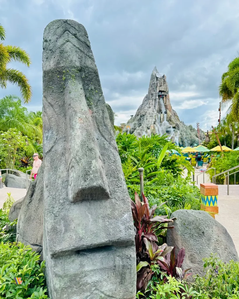 Tiki head with Volcano Bay volcano in background on cloudy day