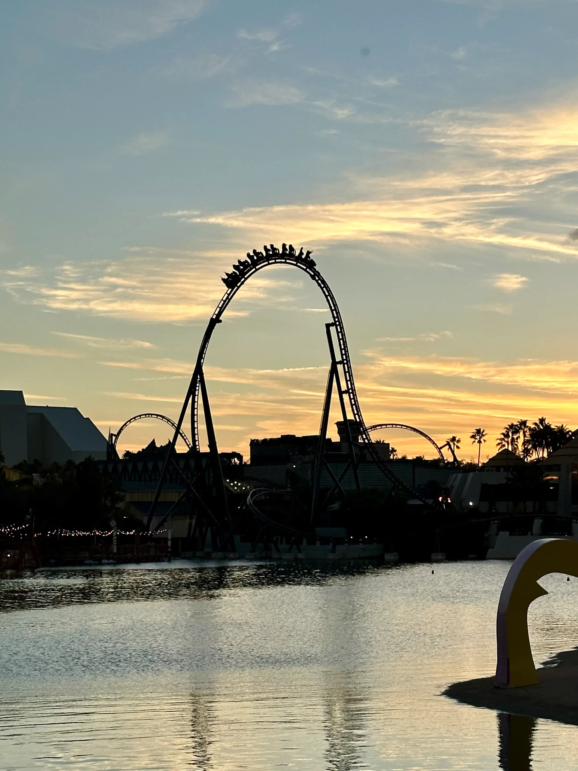 VelociCoaster at Universal Islands of Adventure going over its top hat during sunset