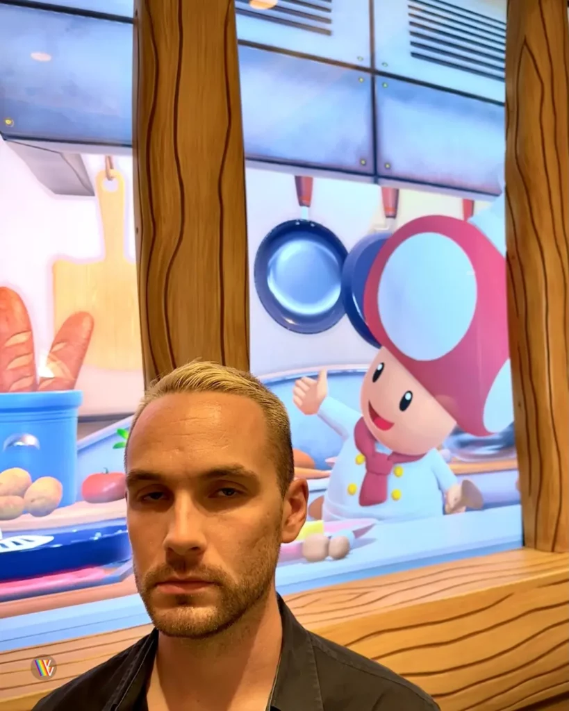 Christian McIlwain angry to be standing next to a screen showing Toad in Toadstool's Cafe at Universal Studios Hollywood